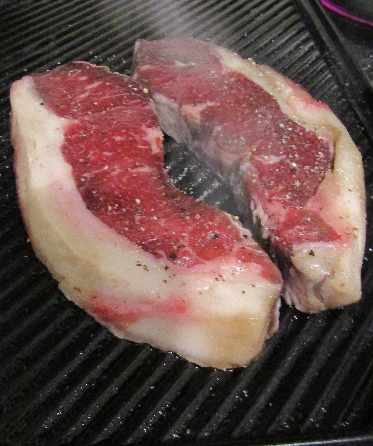 Steaks en cours de cuisson sur une plaque striée
